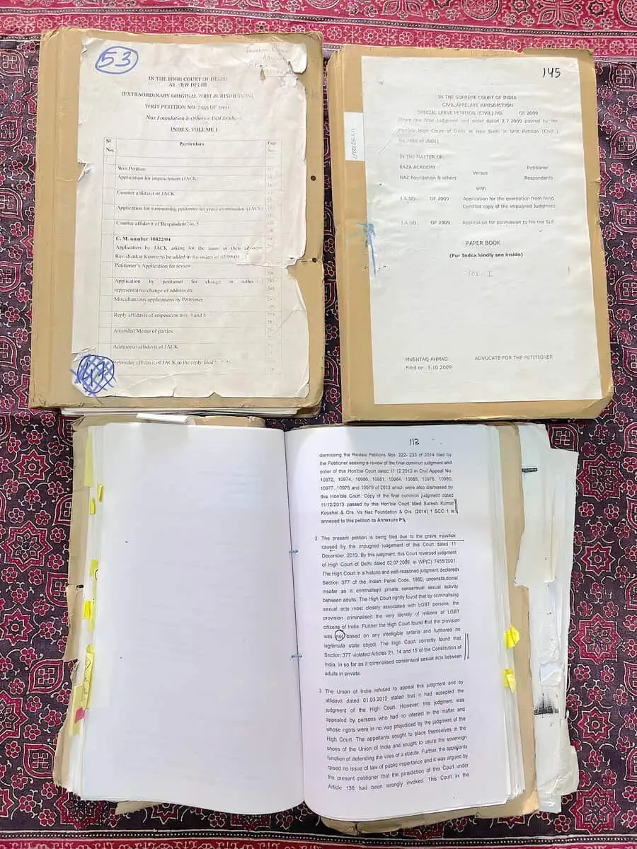 Court paper books from the Naz Foundation Section 377 petitions, open and tagged with page markers.